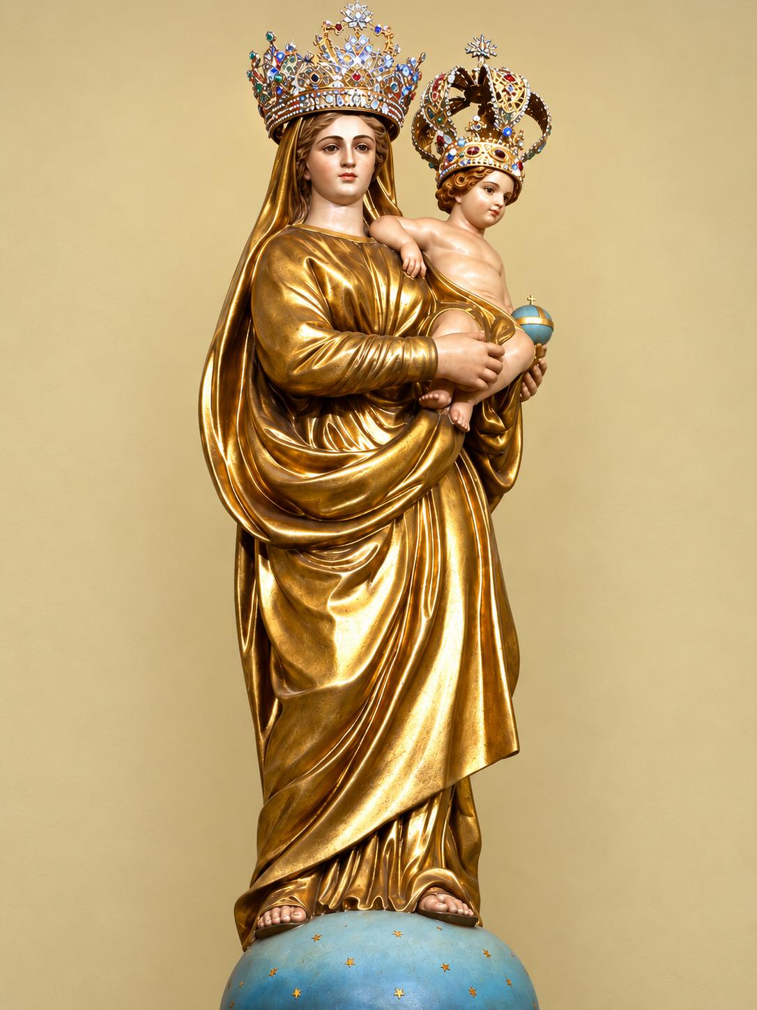 Gilded statue of Mary holding the Christ Child, both wearing jeweled crowns, standing on a starry blue globe