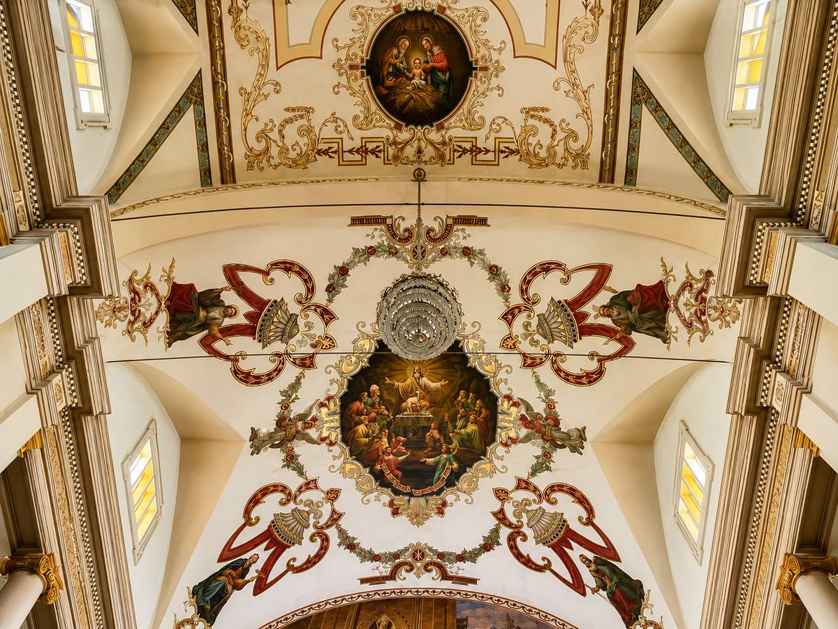Painted ceiling medallions of the Nativity and the Last Supper above the sanctuary